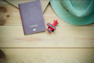 Photo d'un passeport, d'un jouet et d'un chapeau sur une table